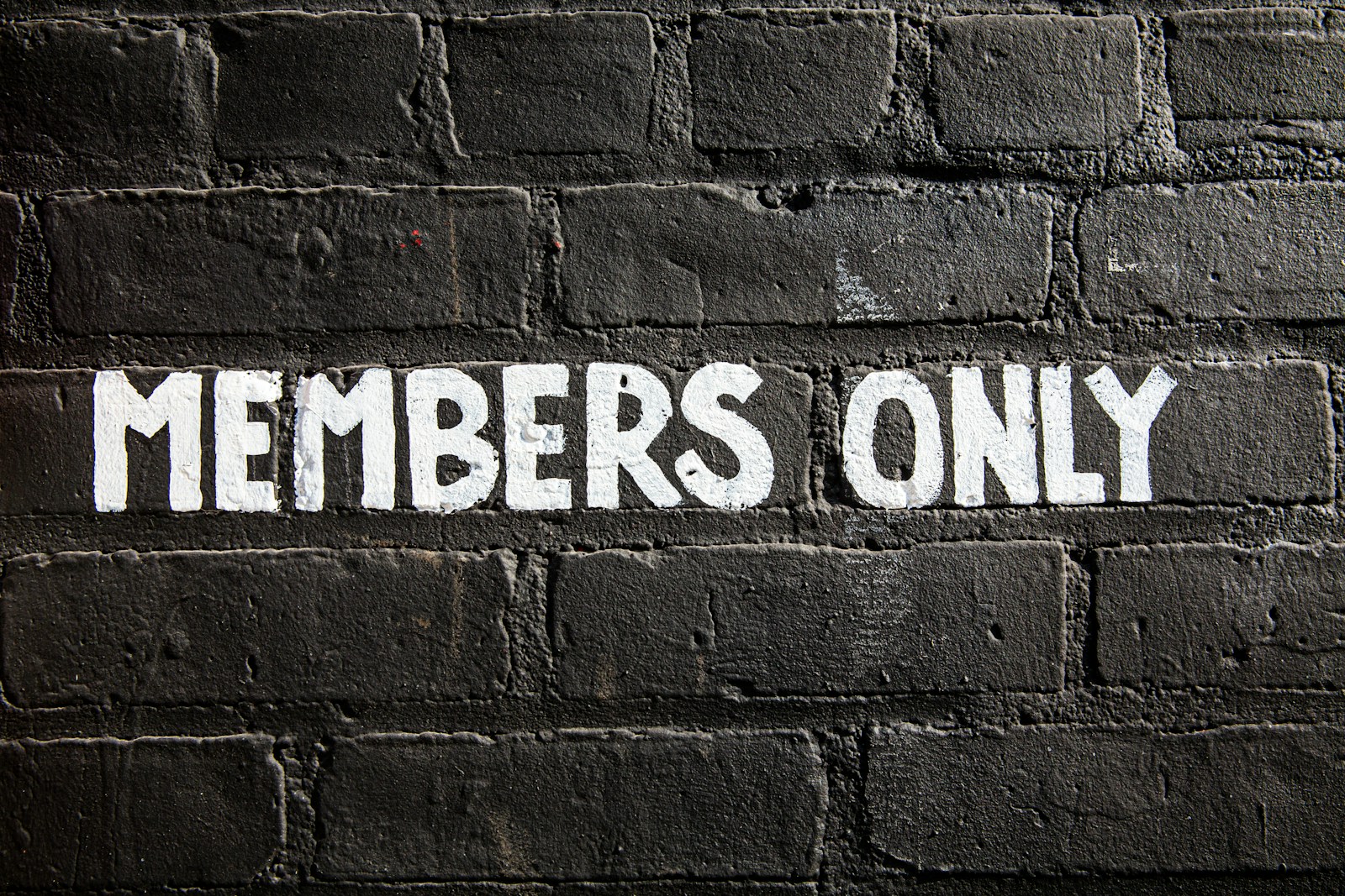 Members only sign on a brick wall